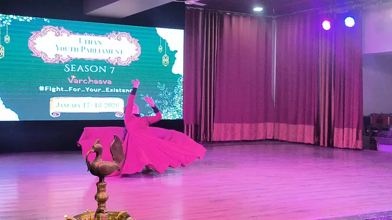 A dancer spins on stage behind the brass lamp, the Season 7 title on the screen