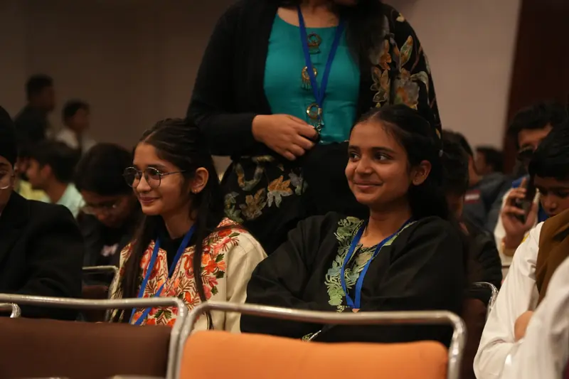 Two delegates smiling in the audience