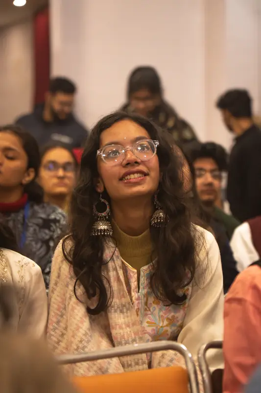 A delegate looks up at the stage, smiling