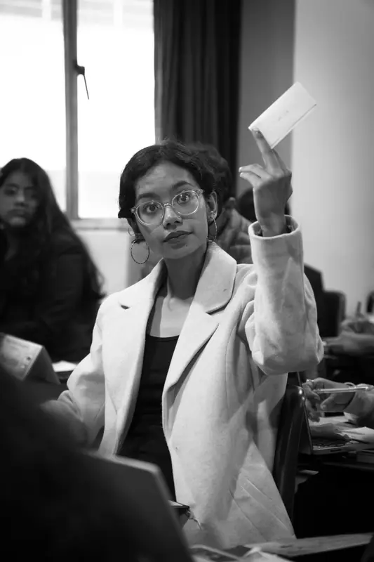 Black-and-white photo of a delegate raising a placard