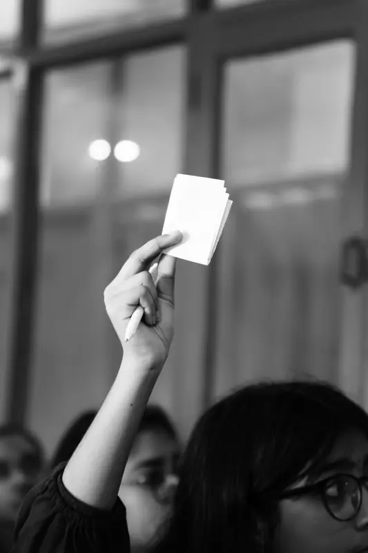 Black-and-white photo of a hand holding up a card