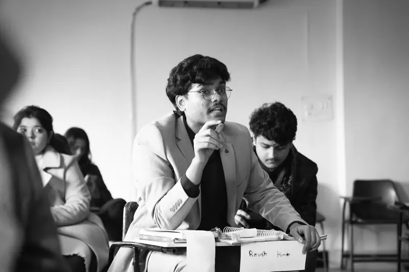 Black-and-white photo of a delegate listening intently at a desk