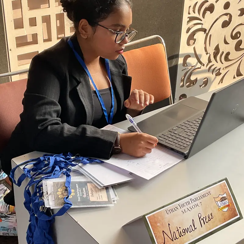 A journalist from the National Press desk taking notes at a laptop